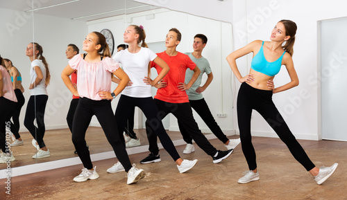 Teenagers participating in dance class with teacher