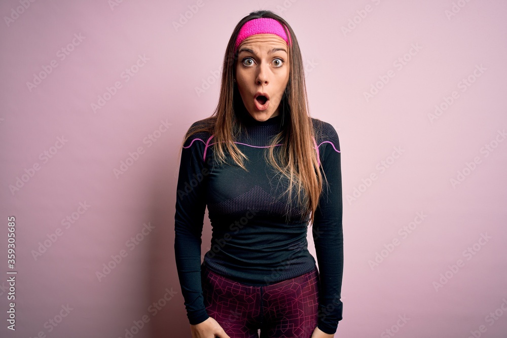 Young blonde fitness woman wearing sport workout clothes over isolated background afraid and shocked with surprise and amazed expression, fear and excited face. Young blonde fitness woman wearing sport workout clothes over isolated background afraid and shocked with surprise and amazed expression, fear and excited face.