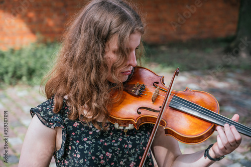 Young woman playing the violin outdoors