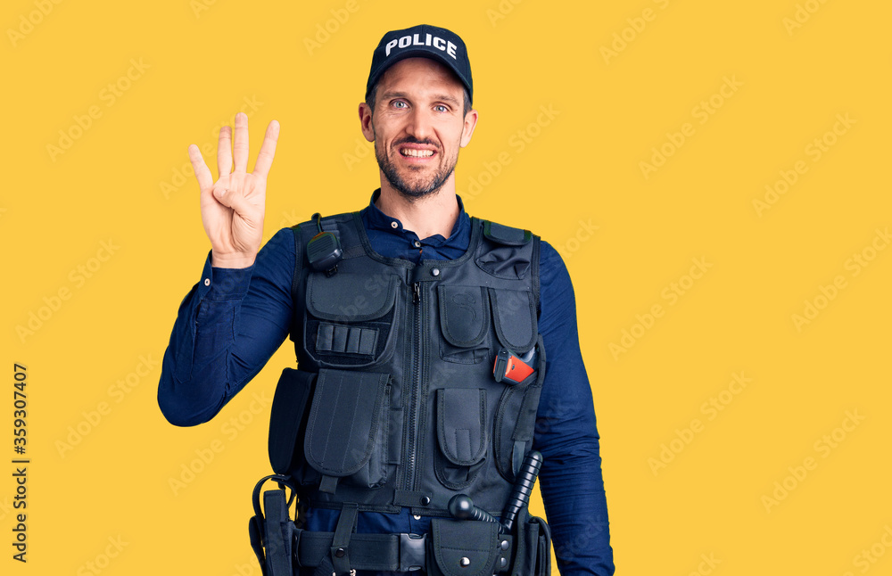 Young handsome man wearing police uniform showing and pointing up with fingers number four while smiling confident and happy. Young handsome man wearing police uniform showing and pointing up with fingers number four while smiling confident and happy.