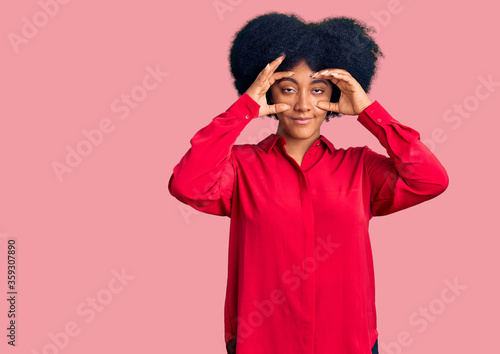 Young african american girl wearing casual clothes trying to open eyes with fingers, sleepy and tired for morning fatigue © Krakenimages.com