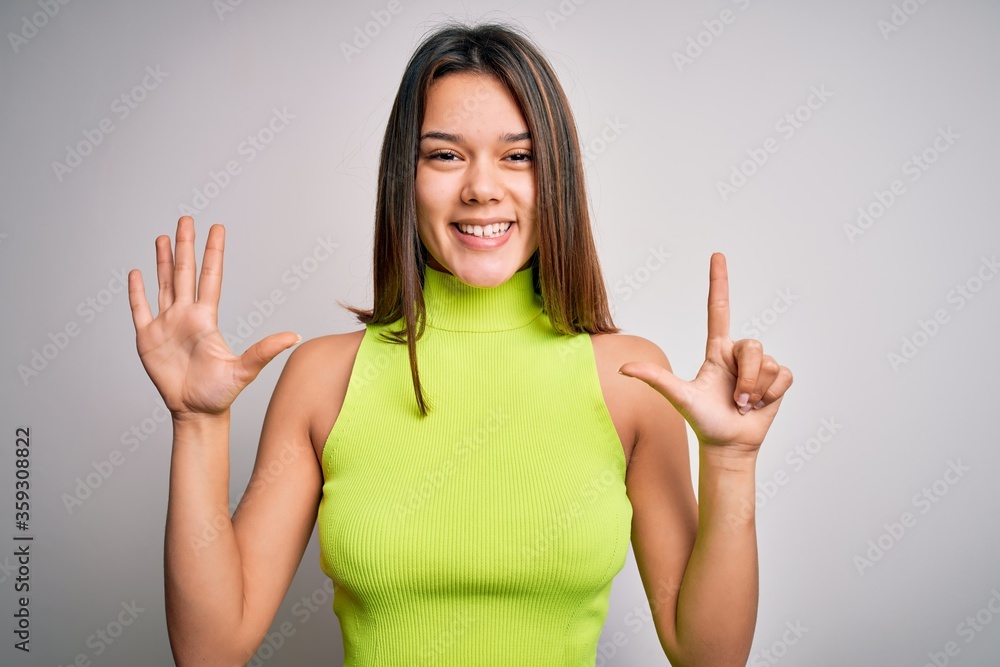 Young beautiful brunette girl wearing casual summer t-shirt over isolated white background showing and pointing up with fingers number seven while smiling confident and happy. Young beautiful brunette girl wearing casual summer t-shirt over isolated white background showing and pointing up with fingers number seven while smiling confident and happy.