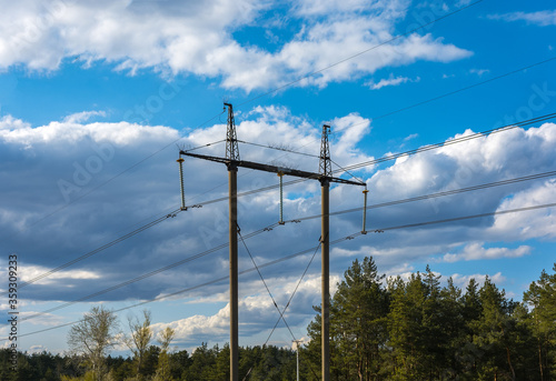  high-voltage power lines at clouds and pine forest.