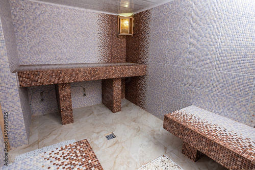 Hamam, traditional turkish sauna. Classic hammam interior design. Mosaic walls and benches.