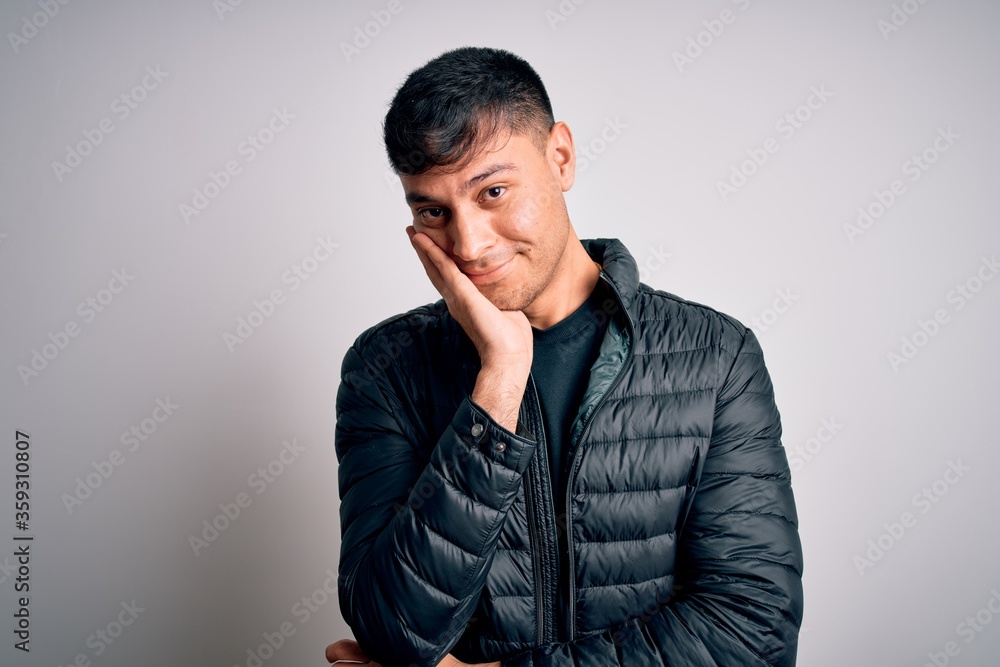 Young handsome hispanic man wearing winter coat standing over white isolated background thinking looking tired and bored with depression problems with crossed arms. Young handsome hispanic man wearing winter coat standing over white isolated background thinking looking tired and bored with depression problems with crossed arms.