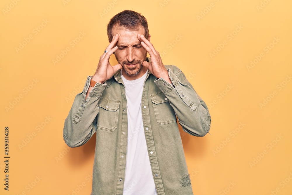 Young handsome man wearing casual clothes with hand on head for pain in head because stress. suffering migraine. Young handsome man wearing casual clothes with hand on head for pain in head because stress. suffering migraine.