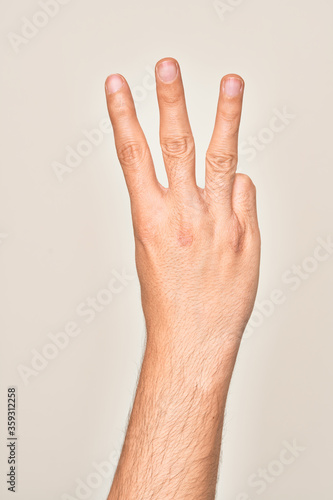 Hand of caucasian young man showing fingers over isolated white background counting number 3 showing three fingers © Krakenimages.com