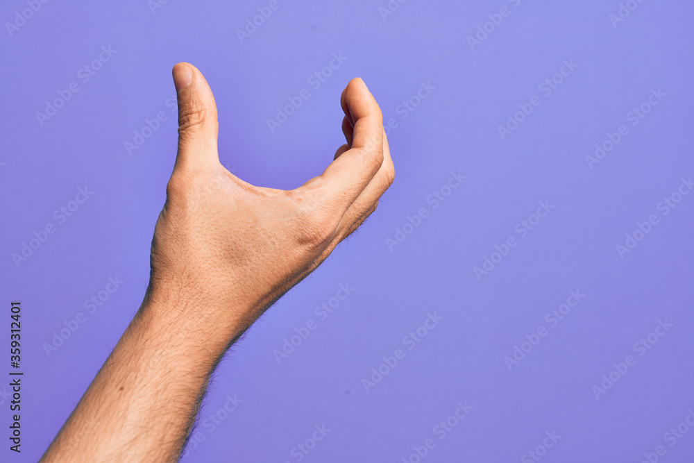 Hand of caucasian young man showing fingers over isolated purple background picking and taking invisible thing, holding object with fingers showing space Hand of caucasian young man showing fingers over isolated purple background picking and taking invisible thing, holding object with fingers showing space