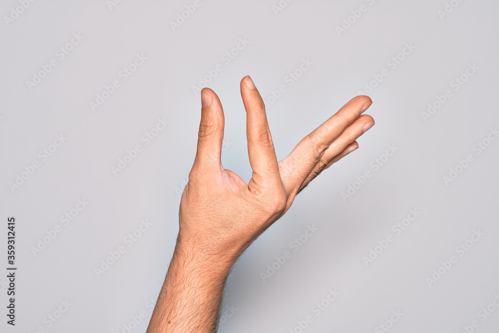Hand of caucasian young man showing fingers over isolated white background picking and taking invisible thing, holding object with fingers showing space
