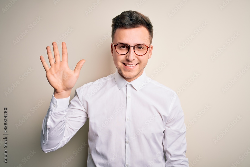 Young handsome business mas wearing glasses and elegant shirt over isolated background showing and pointing up with fingers number five while smiling confident and happy. Young handsome business mas wearing glasses and elegant shirt over isolated background showing and pointing up with fingers number five while smiling confident and happy.