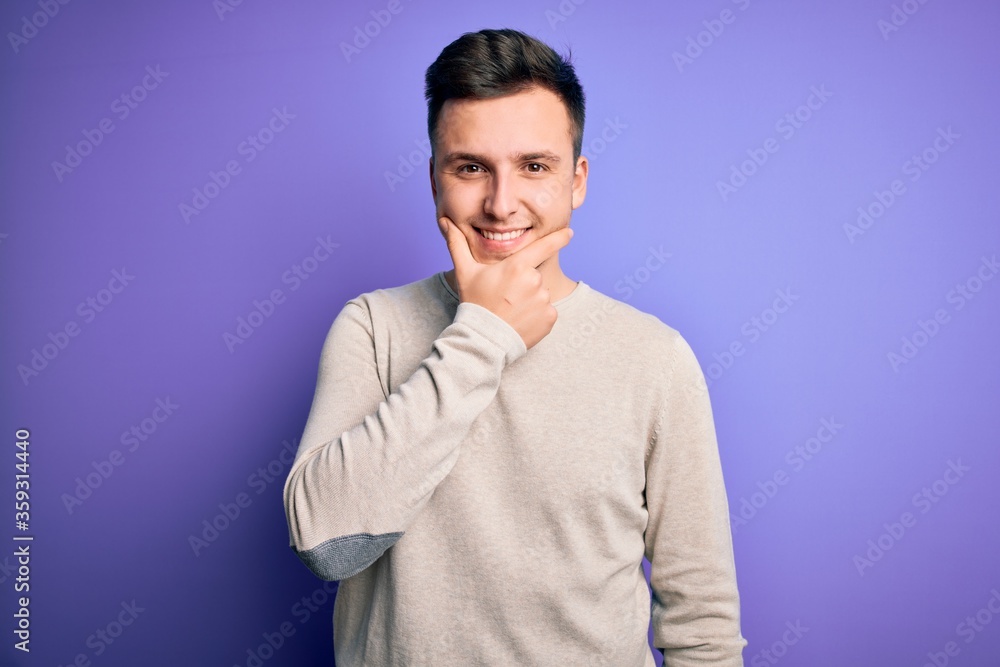 Young handsome caucasian man wearing casual sweater over purple isolated background looking confident at the camera smiling with crossed arms and hand raised on chin. Thinking positive. Young handsome caucasian man wearing casual sweater over purple isolated background looking confident at the camera smiling with crossed arms and hand raised on chin. Thinking positive.