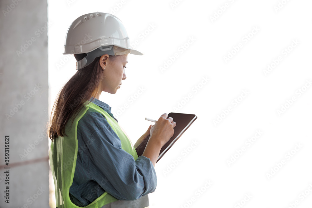 An engineer with a hard hat and a tablet in his hands on a white isolated background An engineer with a hard hat and a tablet in his hands on a white isolated background