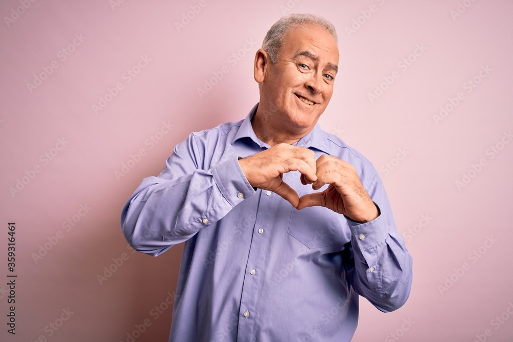 Middle age handsome hoary man wearing casual shirt standing over pink background smiling in love doing heart symbol shape with hands. Romantic concept. Middle age handsome hoary man wearing casual shirt standing over pink background smiling in love doing heart symbol shape with hands. Romantic concept.