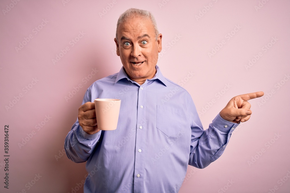 Middle age handsome hoary man drinking mug of coffee over isolated pink background very happy pointing with hand and finger to the side Middle age handsome hoary man drinking mug of coffee over isolated pink background very happy pointing with hand and finger to the side