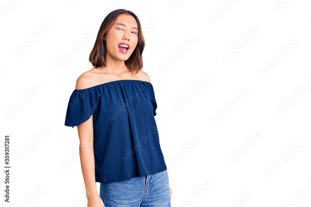 Obraz premium Young beautiful chinese girl wearing casual clothes winking looking at the camera with sexy expression, cheerful and happy face.