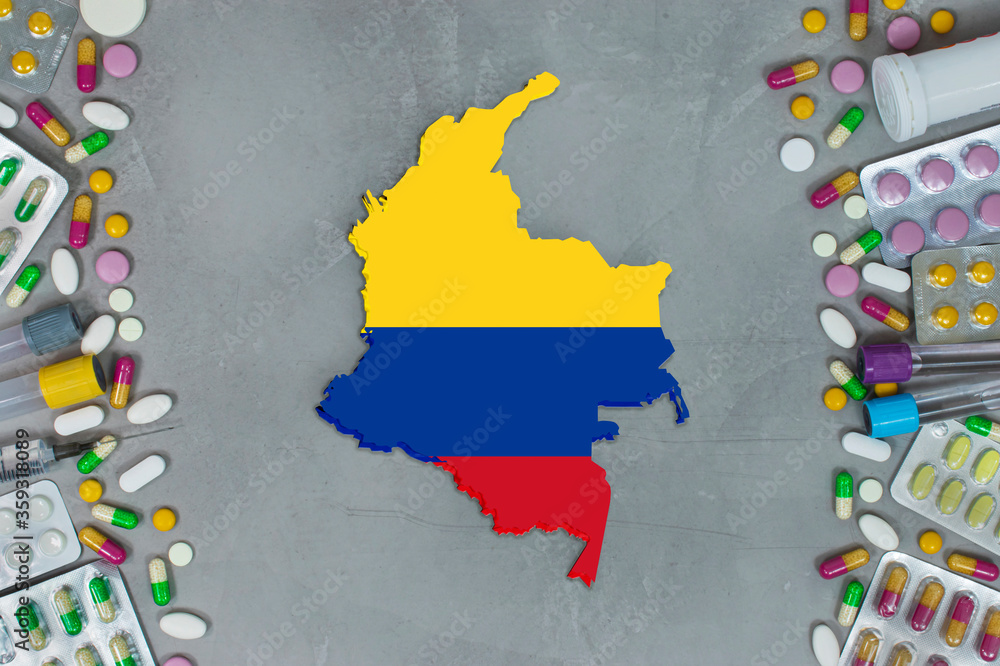 Obraz premium The Colombia State began research for treatment and medicine to combat the pandemic outbreak disease coronavirus. Medicine, pills, needles, syringes and Colombia map and flag on gray background.