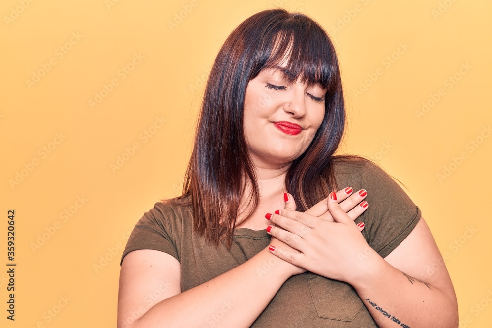 Young plus size woman wearing casual clothes smiling with hands on chest, eyes closed with grateful gesture on face. health concept. Young plus size woman wearing casual clothes smiling with hands on chest, eyes closed with grateful gesture on face. health concept.