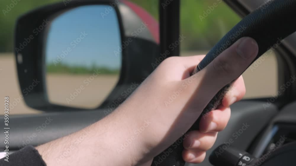 The hand of the young lad on the wheel of the car The hand of the young lad on the wheel of the car