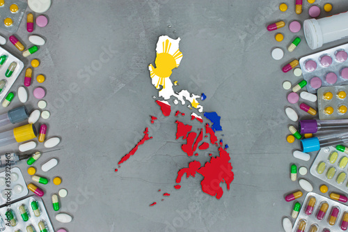 The Philippines State began research for treatment and medicine to combat the pandemic outbreak disease coronavirus. Medicine, pills, needles, syringes and Philippines map and flag on gray background.