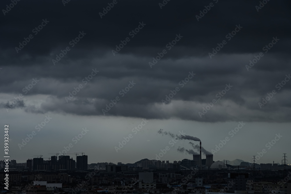 factory funnels with thick smoke with in a lowkey cloudy day