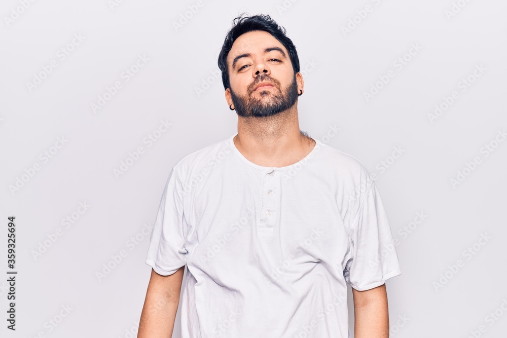 Young hispanic man wearing casual clothes relaxed with serious expression on face. simple and natural looking at the camera. Young hispanic man wearing casual clothes relaxed with serious expression on face. simple and natural looking at the camera.
