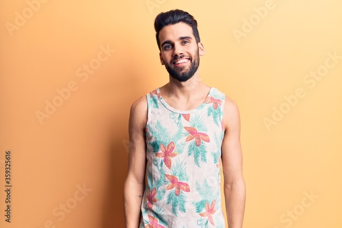 Young handsome man with beard wearing summer sleeveless t-shirt with a happy and cool smile on face. lucky person.