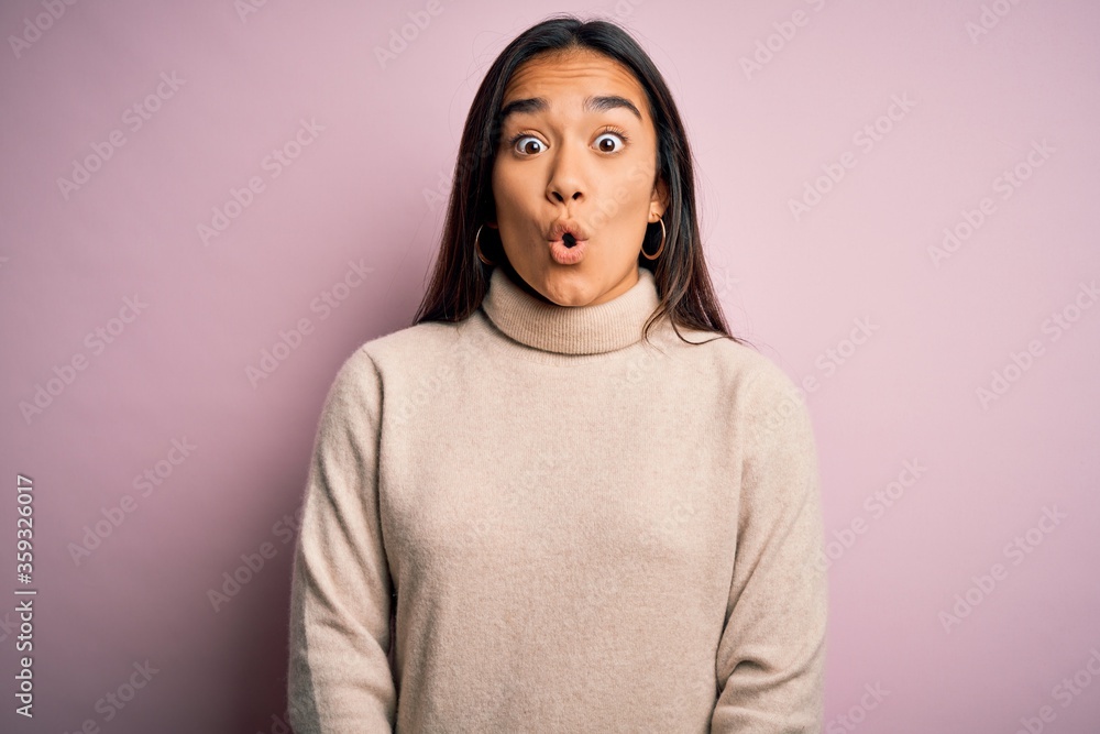 Fototapeta premium Young beautiful asian woman wearing casual turtleneck sweater over pink background afraid and shocked with surprise expression, fear and excited face.
