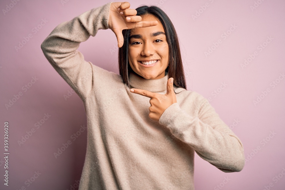 Young beautiful asian woman wearing casual turtleneck sweater over pink background smiling making frame with hands and fingers with happy face. Creativity and photography concept. Young beautiful asian woman wearing casual turtleneck sweater over pink background smiling making frame with hands and fingers with happy face. Creativity and photography concept.