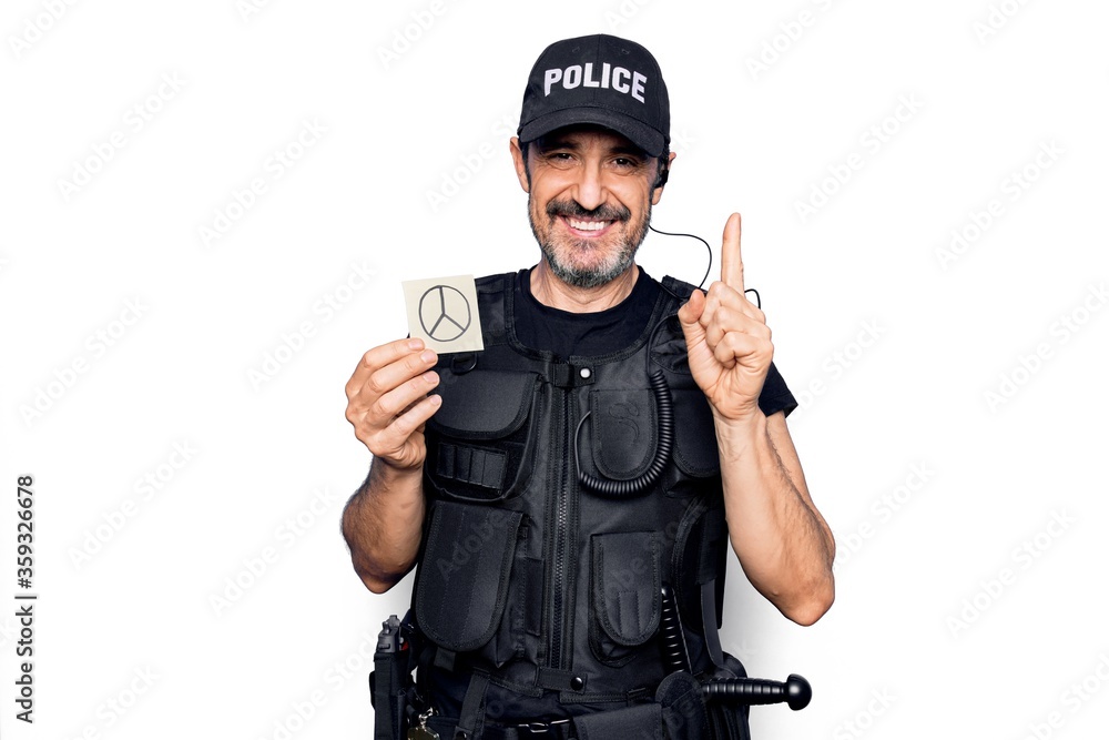 Middle age policeman wearing police uniform holding reminder paper with peace symbol smiling with an idea or question pointing finger with happy face, number one Middle age policeman wearing police uniform holding reminder paper with peace symbol smiling with an idea or question pointing finger with happy face, number one