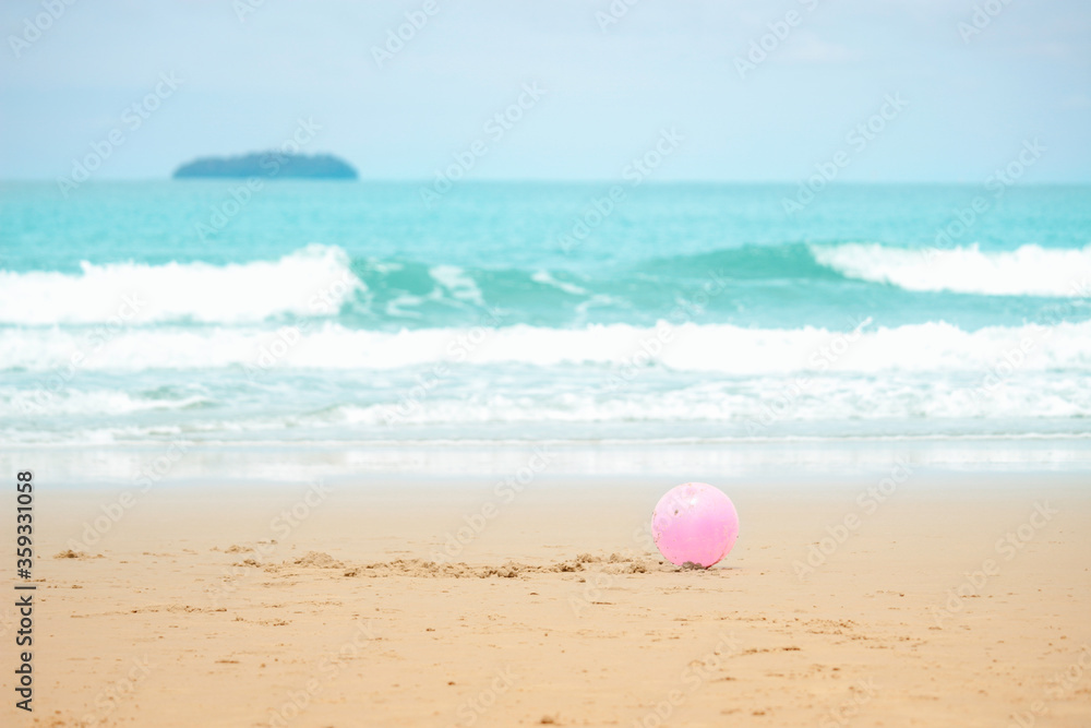 Pink ball on sandy summer beach with blue sea, playing and having fun with sandat on tropical beach Pink ball on sandy summer beach with blue sea, playing and having fun with sandat on tropical beach
