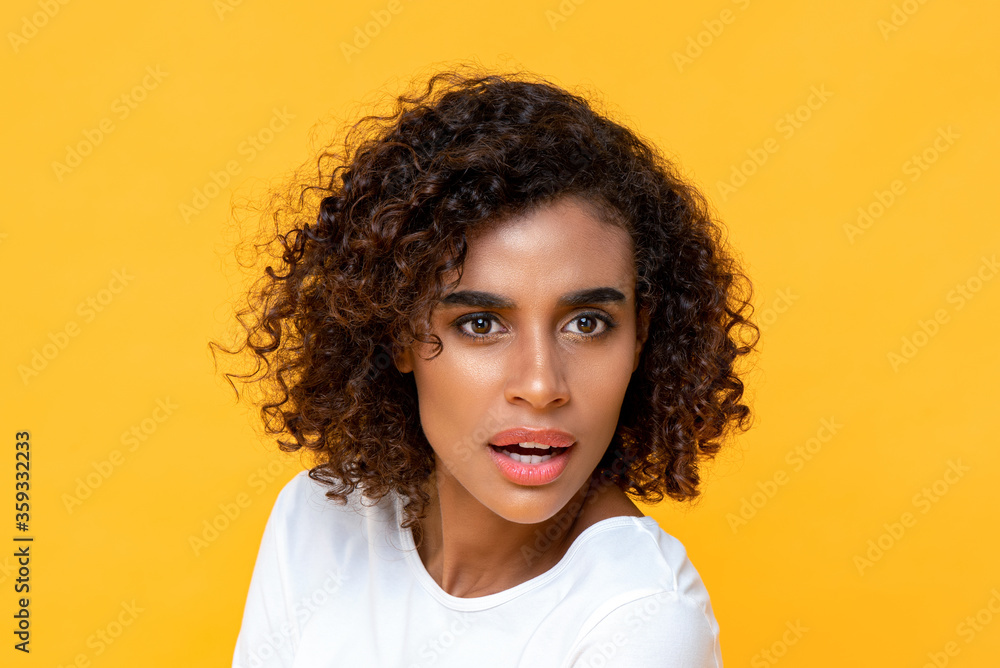Close-up portrait of curious young beautiful African American woman looking astonished isolated studio yellow background Close-up portrait of curious young beautiful African American woman looking astonished isolated studio yellow background