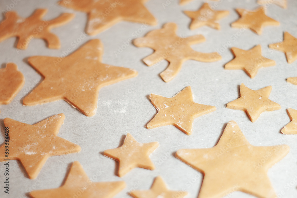 Star-shaped gingerbread cookie with on parchment. Christmas dessert. The process of baking cookies. Gingerbread dough.