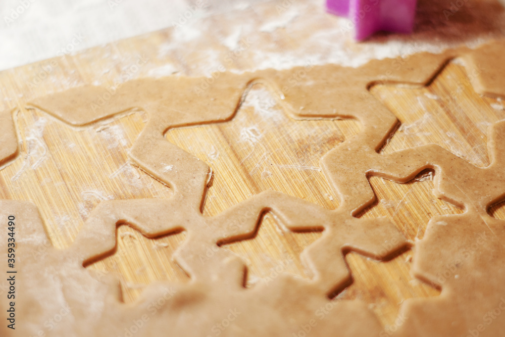 Star shaped gingerbread cookie on a wooden board. Christmas dessert. The process of baking cookies. Gingerbread dough. Star shaped gingerbread cookie on a wooden board. Christmas dessert. The process of baking cookies. Gingerbread dough.