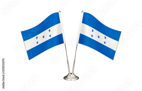 Honduras table flag isolated on white ground. Two flag poles with flags and Honduras flag on the table.