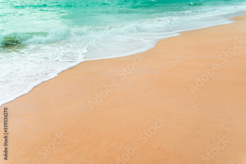 Top view of sand and water clean beach and white sand in summer with sun light blue sky and bokeh background.