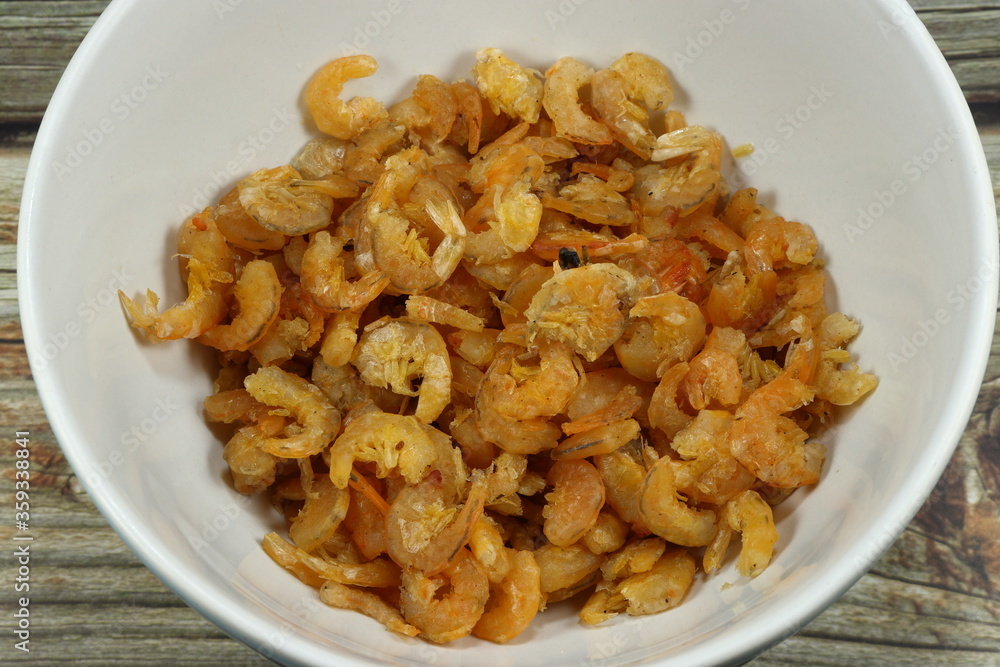 Pile of fried dried shrimp in the bowl. Famous ingredients in Thai cuisine. Salty shrimp preparation. Pile of fried dried shrimp in the bowl. Famous ingredients in Thai cuisine. Salty shrimp preparation.