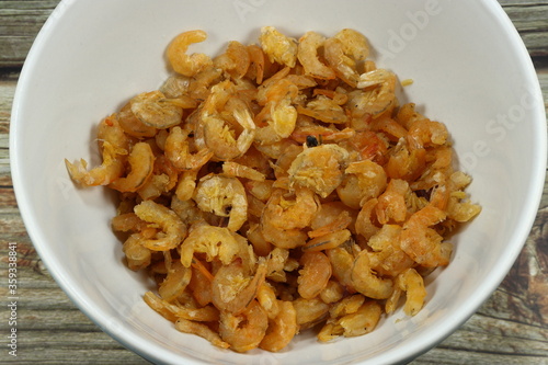 Pile of fried dried shrimp in the bowl. Famous ingredients in Thai cuisine. Salty shrimp preparation. 