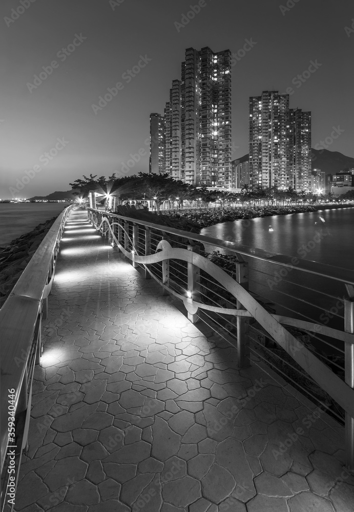 Seaside promenade and high rise residential building in Hong Kong city at night