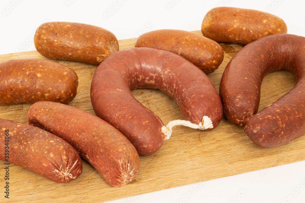 Presentation of sausage salami and bacon on a cutting board on a white background. Presentation of sausage salami and bacon on a cutting board on a white background.