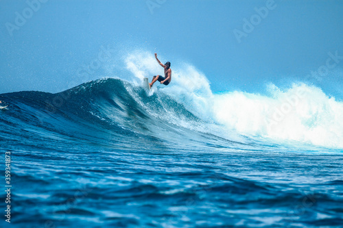 Surfer on perfect blue aquamarine wave, empty line up, perfect for surfing, clean water, Indian Ocean