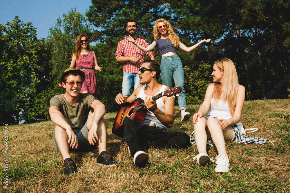 Fototapeta premium Friends having fun together in the park. Young people welcoming each other