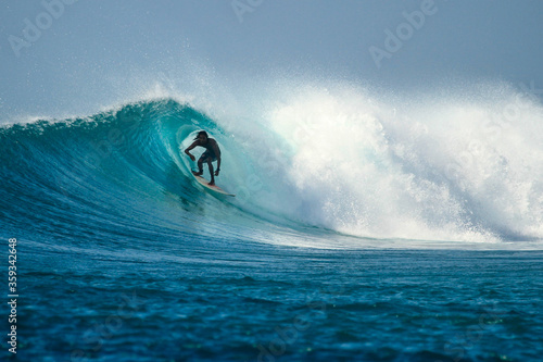 Surfer on perfect blue wave, in the barrel, clean water, Indian Ocean