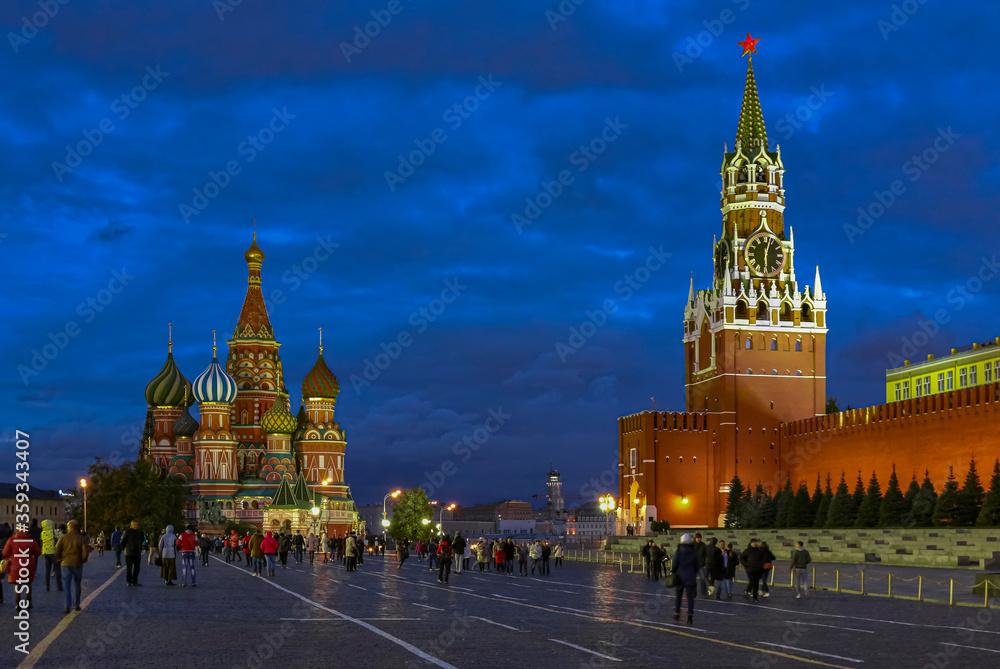 Kremlin Spasskaya tower and Saint Basil's Cathedral by Lenin Mausoleum on Red Square with people at night, Moscow Russia