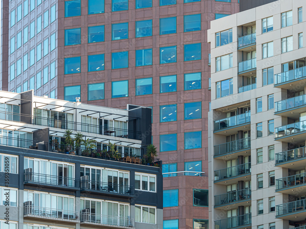 Fototapeta premium Multi-dwelling modern apartment buildings with balconies, zoom, close up. Apartments in a strata living scheme of common property in a central business district of a busy city.