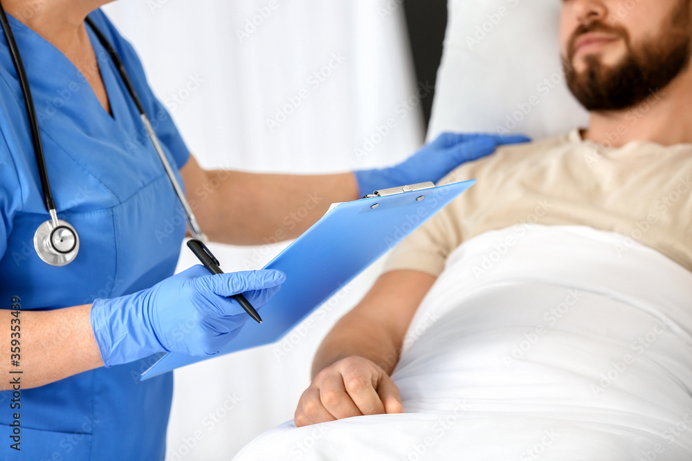 Mature female doctor working with patient in hospital room Mature female doctor working with patient in hospital room
