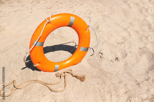 Bright lifebuoy ring on beach photo