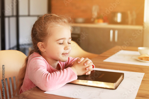 Little girl with Bible pray...