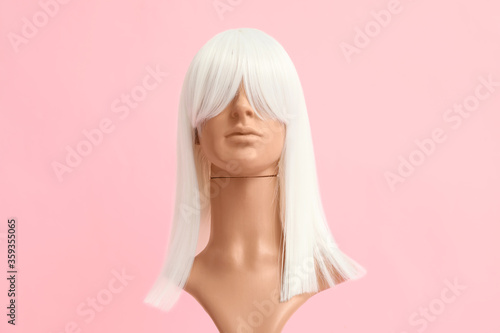 Mannequin with female wig on color background