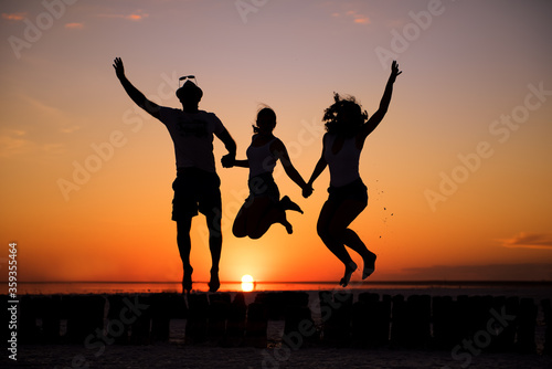 Shot of a carefree family of four jumping for joy at the beach