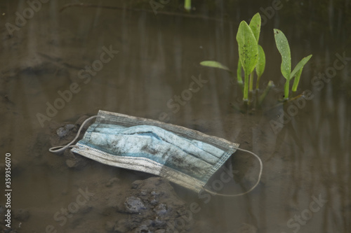 Face mask debris in the river. Medical face masks polluting rivers and lakes since Coronavirus COVID-19. Frumushika Nova, Odessa region, Ukraine, Eastern Europe photo